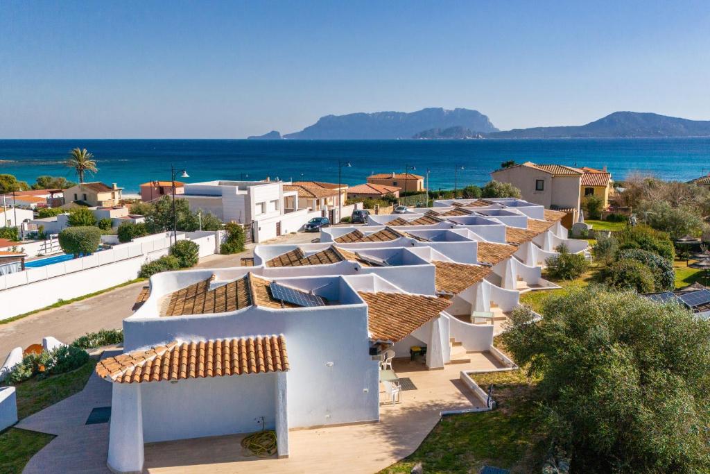 a row of white houses with the ocean in the background at Sea View House 6 in Olbia