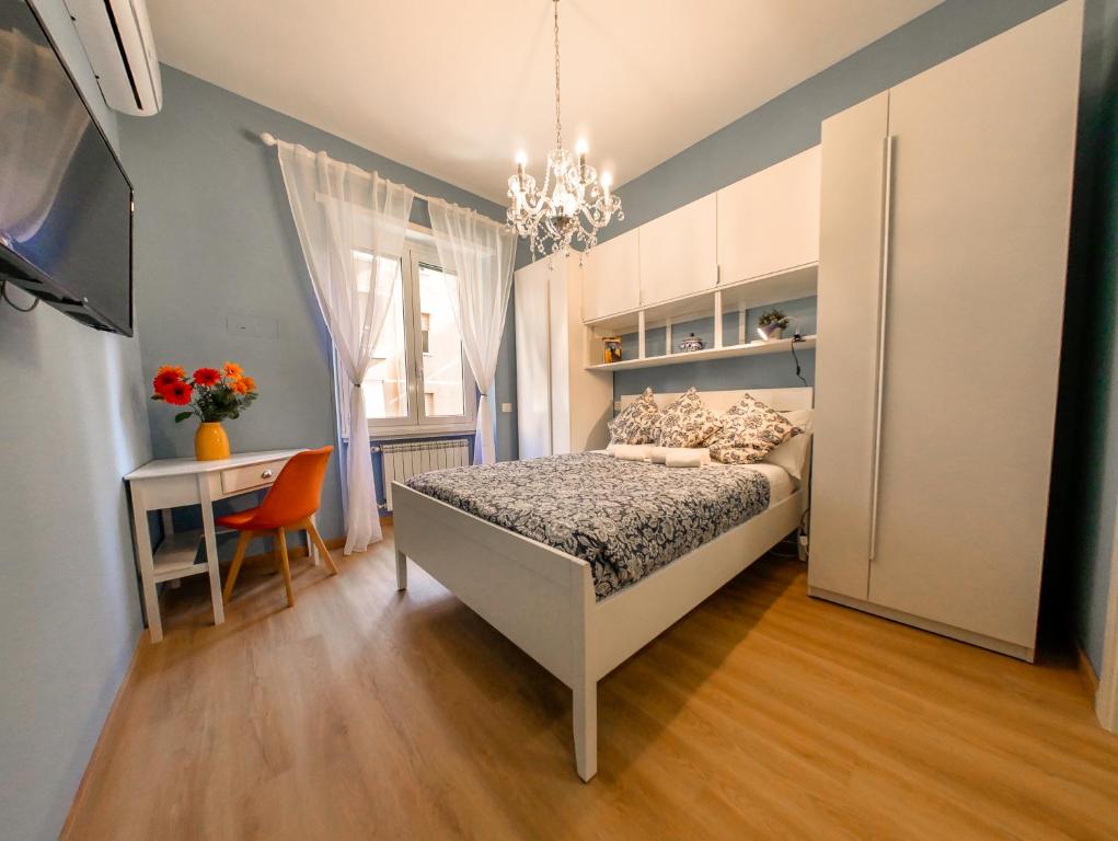 Dormitorio con cama, escritorio y TV en Chic Modern 2-Bedroom near Metro, en Roma
