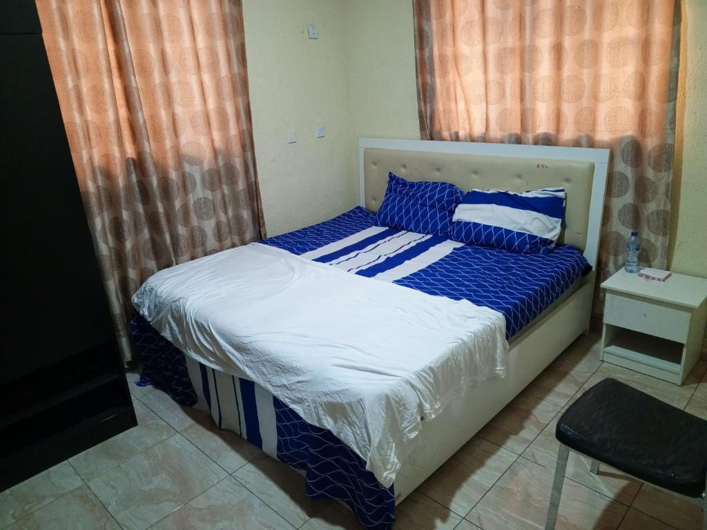 una camera con letto e lenzuola bianche e blu di Treasure Apartment a Lagos