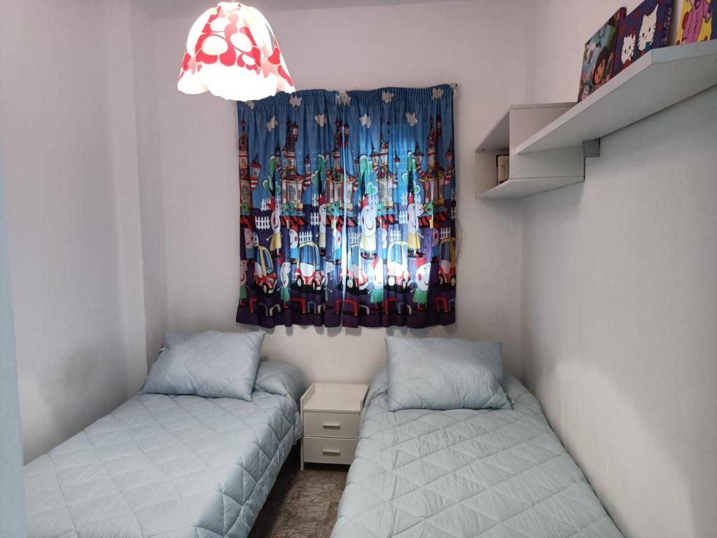 a small room with two beds and a curtain at Apartamento en Motril-costa de Granada in Motril