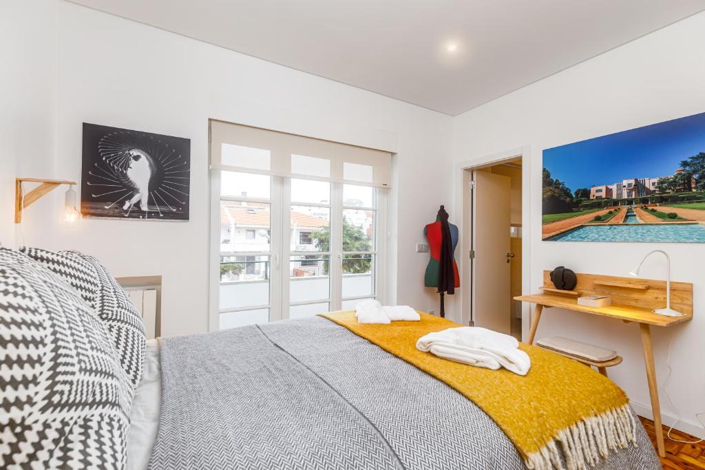 a bedroom with a bed and a desk and a window at Augusto - your family house in the heart of Lisbon in Lisbon