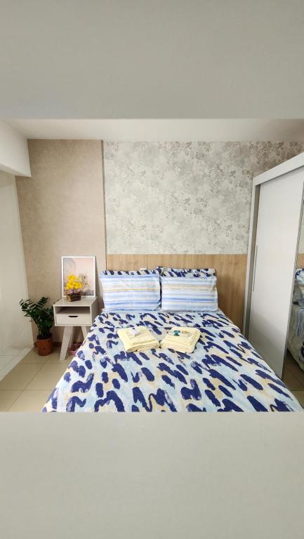 1 dormitorio con 1 cama con edredón azul y blanco en Confortável Studio no Park Sul próximo ao aeroporto, en Brasilia