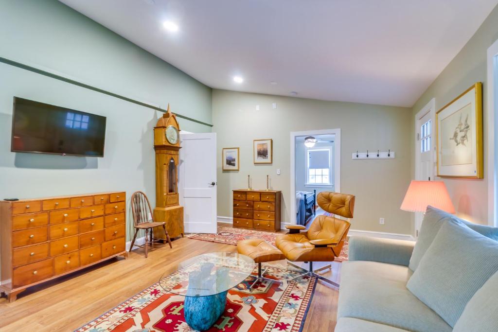 a living room with a couch and a clock at Orange Cottage with Hiking Access 1 Mi to Lake Anna in Kirk O'Cliff