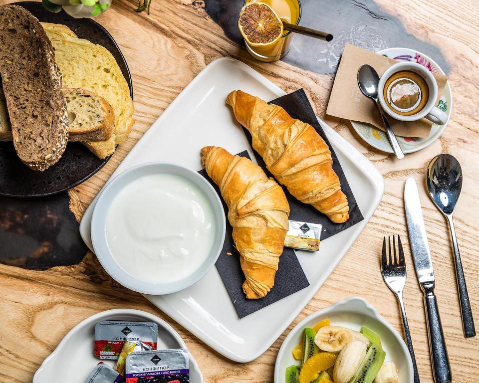 a table with a plate of bread and croissants and coffee at Les Fleurs Boutique Hotel in Sofia