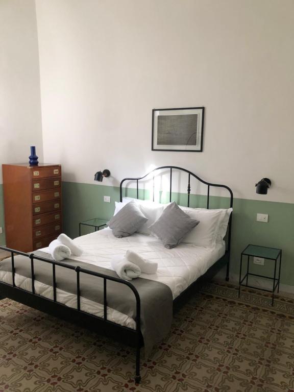 una camera da letto con letto, lenzuola e cuscini bianchi di Caves Apartment a Bari