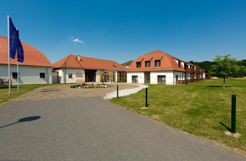 um edifício com telhados vermelhos e uma estrada ao lado de um campo em Hotel Kloster Nimbschen 4 Sterne em Grimma