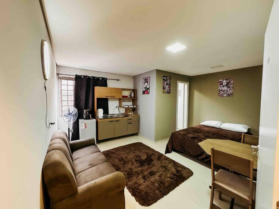1 dormitorio con sofá, 1 cama y cocina en Apartamento ótima localização, en Passo Fundo