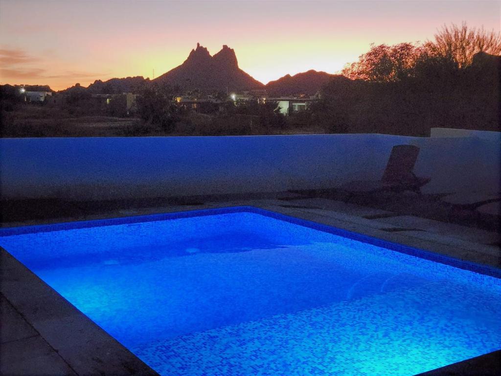 uma piscina azul com um pôr-do-sol ao fundo em Casa Espaciosa Alberca Privada En fraccionamiento Country Club de Golf em San Carlos
