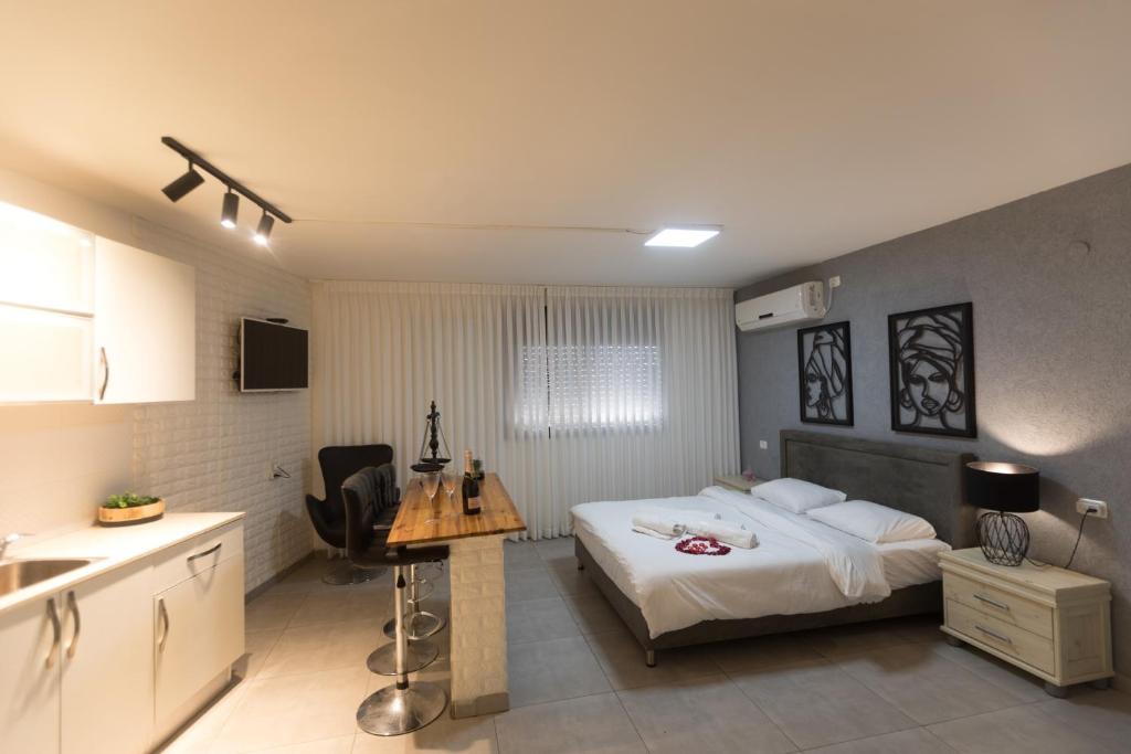 a bedroom with a bed and a desk in it at Sweet Dreams Apartment in Tiberias