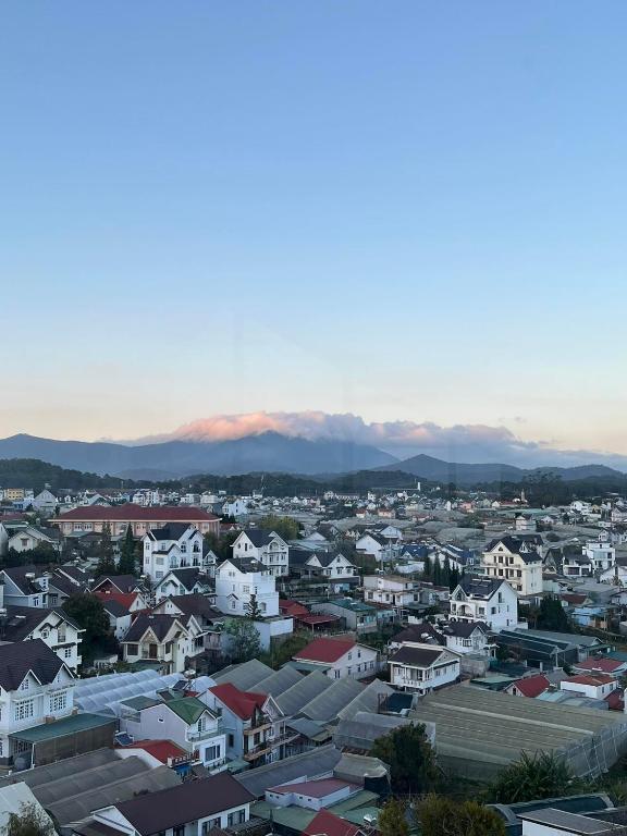 a city skyline with houses and mountains in the background at SAFFRON Dalat in Da Lat