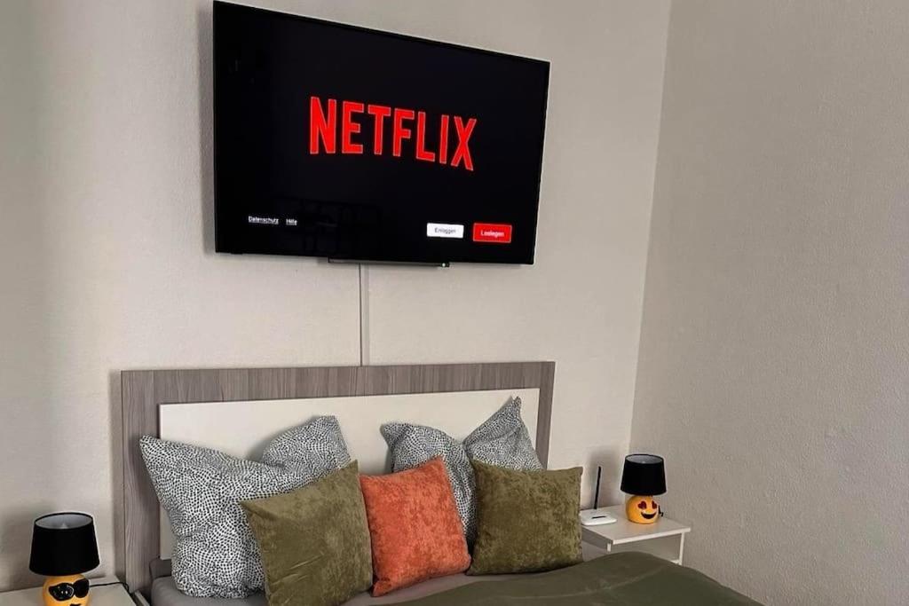 a tv on the wall above a bed with pillows at Stilvolles Zuhause in Magdeburg