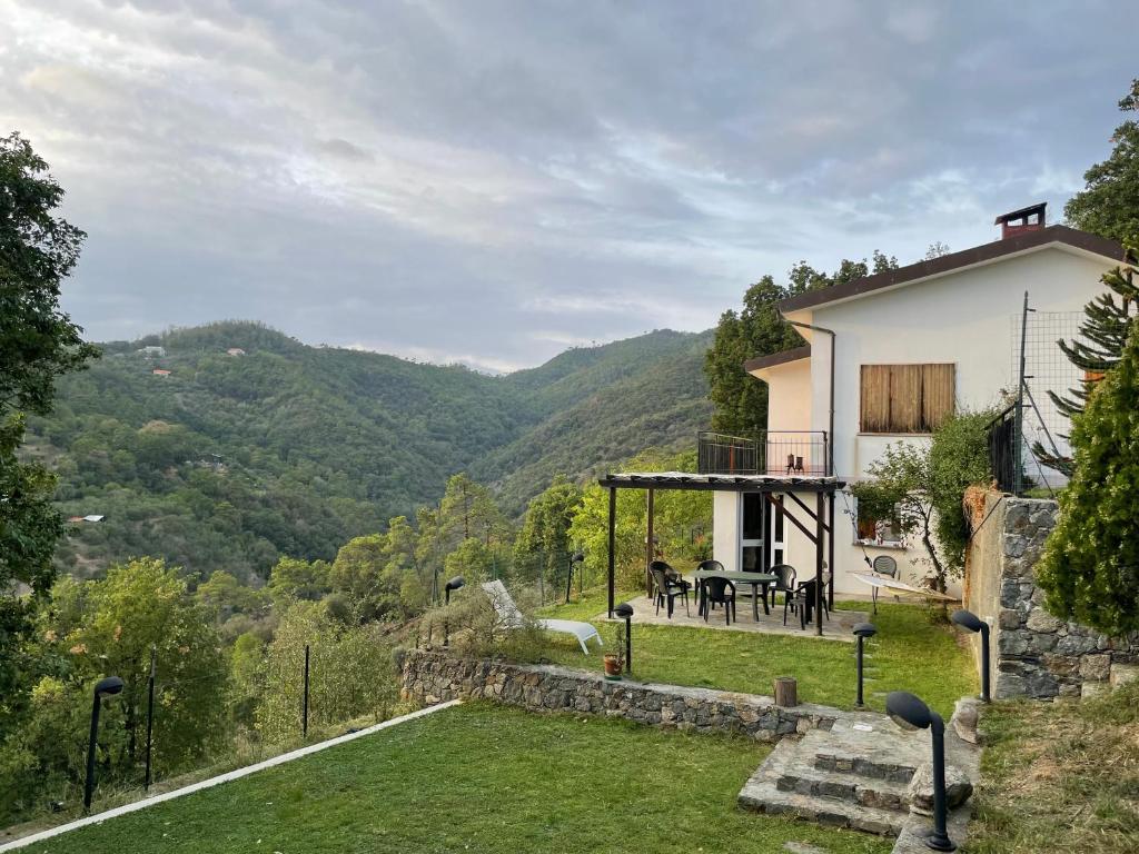 a house with a table and chairs in a yard at Casa in campagna: Completo Relax in Albissola Marina