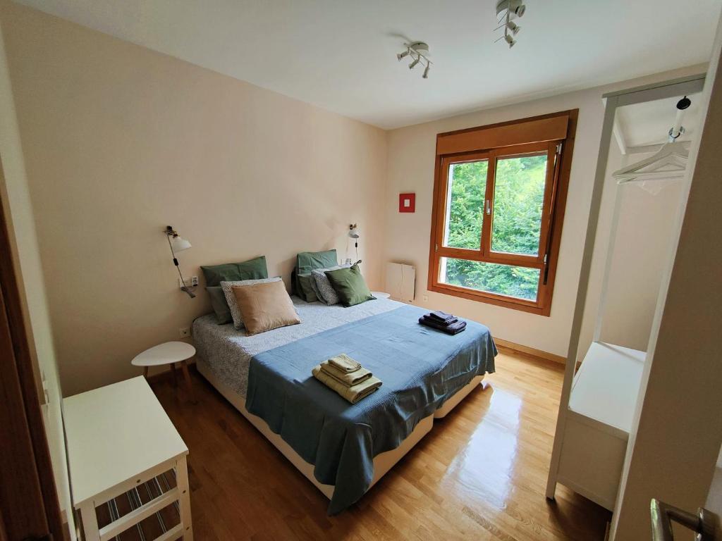 a bedroom with a bed and a window at Ventana al Paraíso del Oso - Somiedo. Window to Bear Paradise - Somiedo in Pola de Somiedo