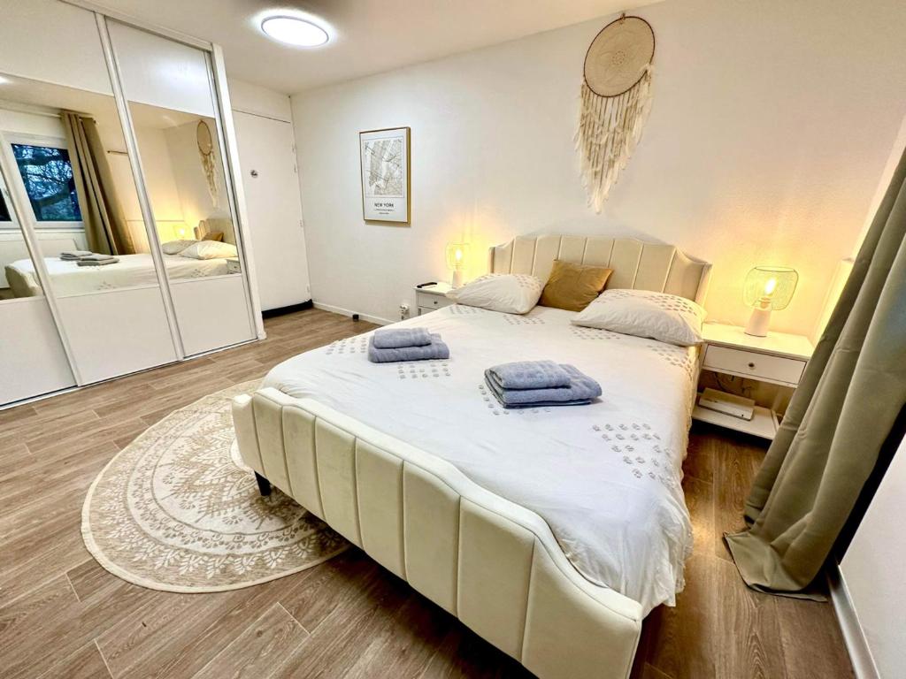 - une chambre avec un grand lit blanc et un miroir dans l'établissement MamZelle TouTapié Coeur de Vannes, à Vannes