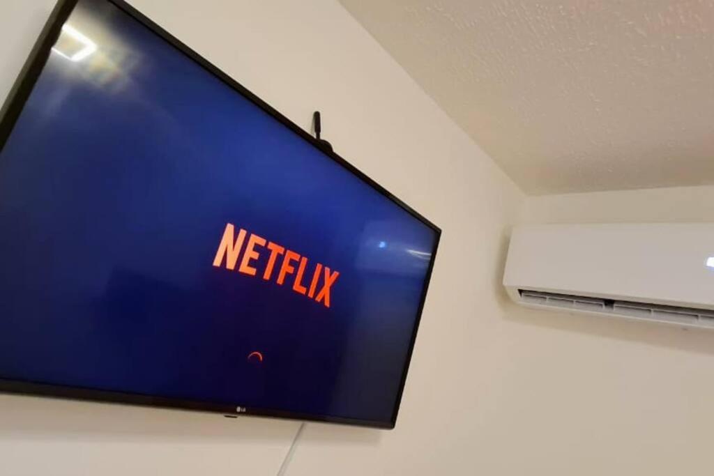 un televisor en una pared con un cartel de netflix en él en Apartamento completo, privativo, ótima localização (Próximo ao Aeroporto), en Campo Grande
