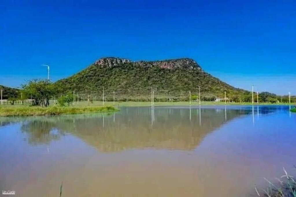 a mountain sitting on top of a large body of water at Cabaña “La Herencia” Paraguarí in Paraguarí