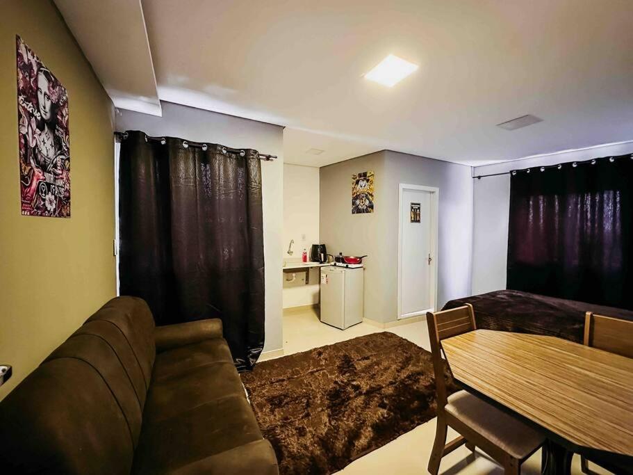 ein Wohnzimmer mit einem Sofa und einem Tisch in der Unterkunft Studio próximo Aeroporto e UPF in Passo Fundo