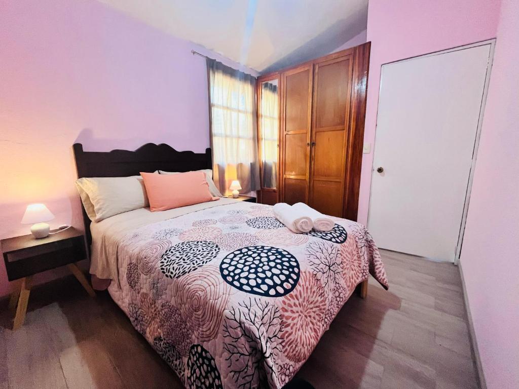 a bedroom with a bed with a black and white comforter at La Casita in Pátzcuaro