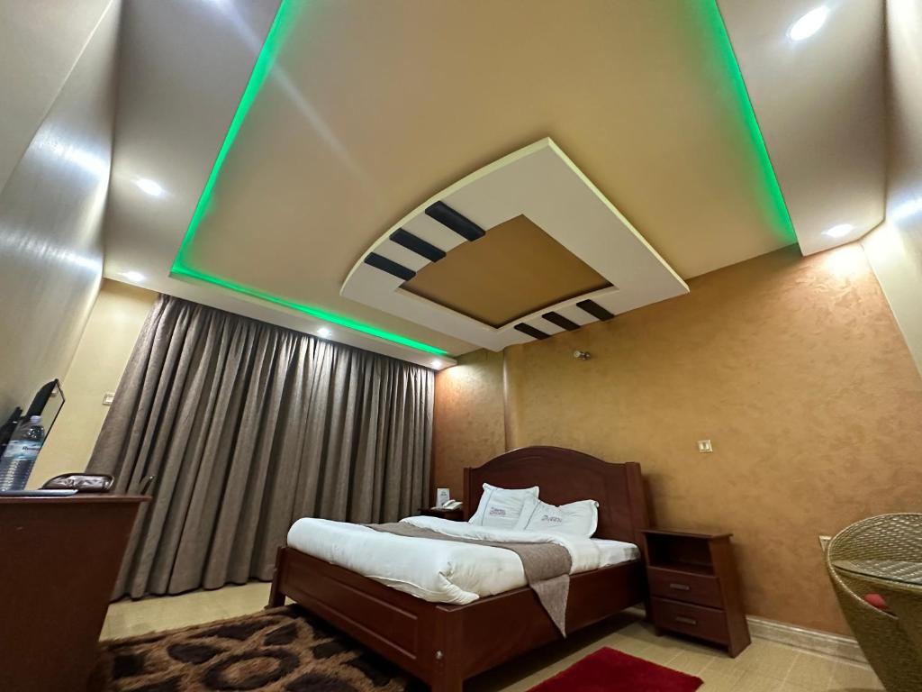 a hotel room with a bed with a green lighting at Kampala Executive Suites in Kampala