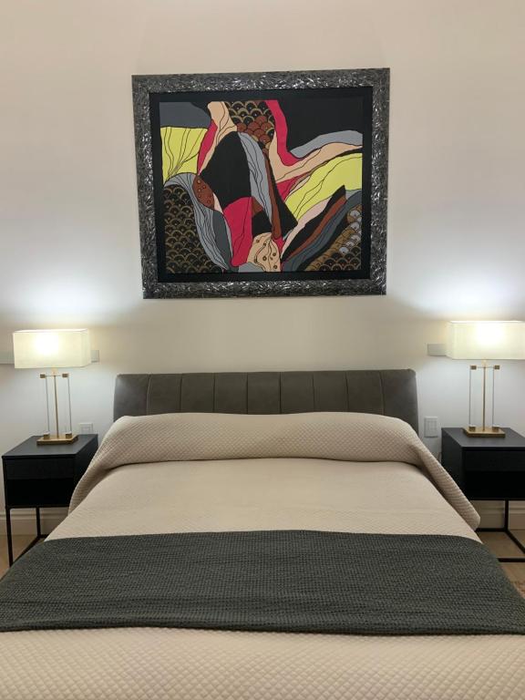 a bedroom with a bed with a painting on the wall at Bari Downtown Luxury Apartment in Bari