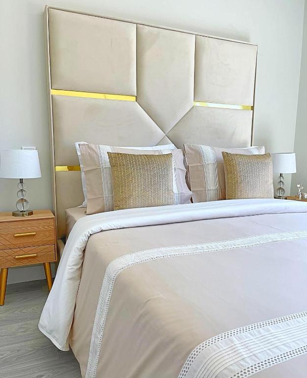 ein großes weißes Bett mit einem großen Kopfteil und Kissen in der Unterkunft Home Silva Sanches in Quinta do Conde