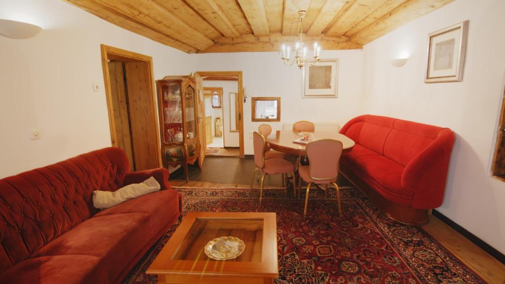 a living room with a red couch and a table at Ferienwohnung Arbesgassl in Hall in Tirol