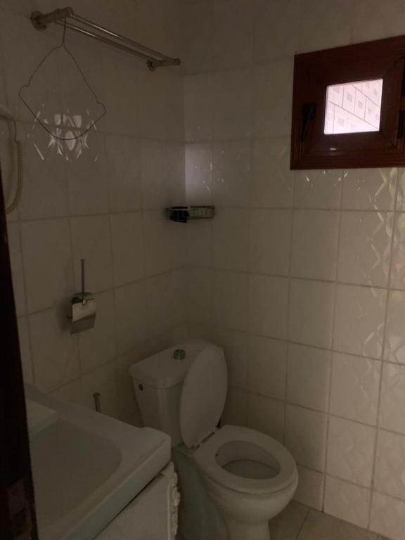 a bathroom with a toilet and a tub and a window at Résidence Longchamp in Douala