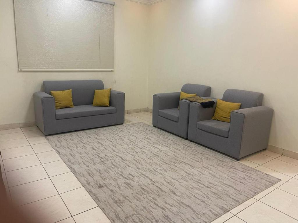 two couches with yellow pillows in a room at Coov AlAnbarya in Al ‘Awālī