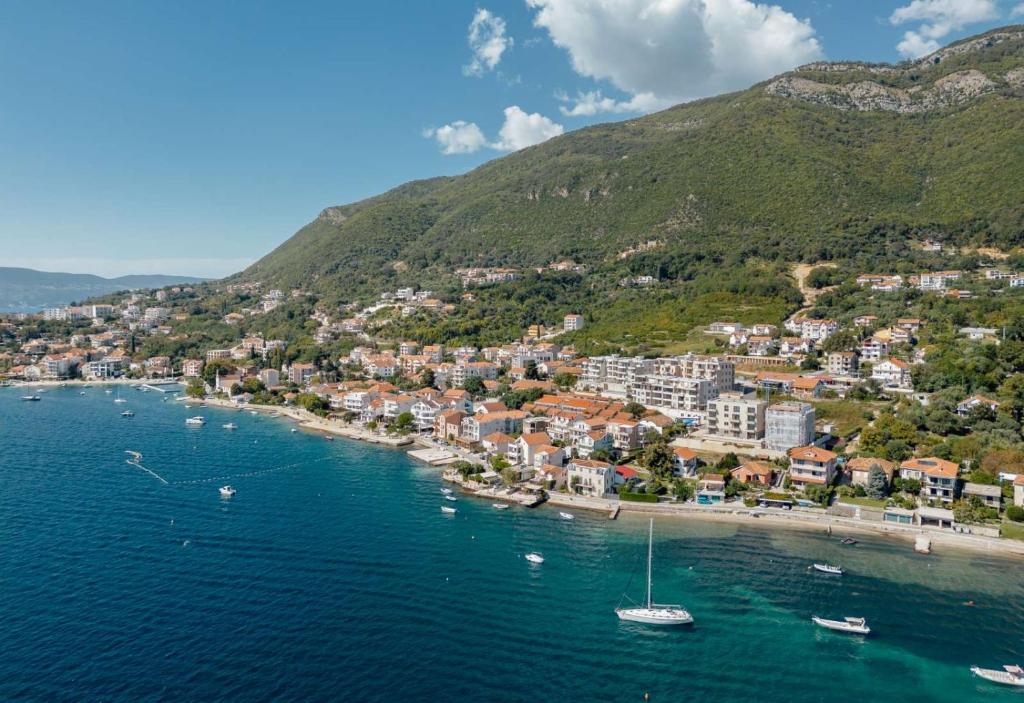 eine Luftansicht auf einen Strand mit Booten im Wasser in der Unterkunft Bella Vista Apartments in Baošići