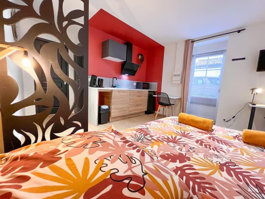 a bedroom with a large bed and a red wall at LA FEUILLERAIE N1-Standingappart-Wifi-proche ville in Fontenay-le-Comte