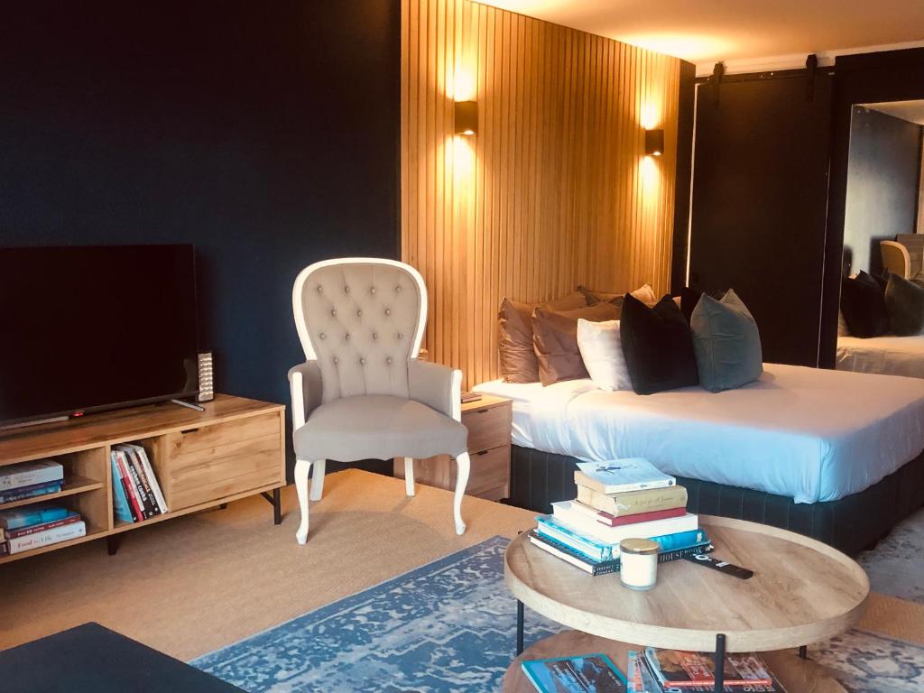 a hotel room with a bed and a tv and a chair at Studio Blue in Mouille Point in Cape Town