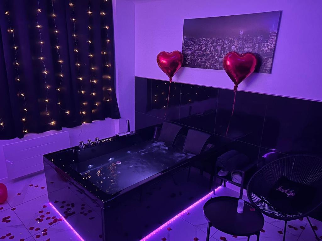 a purple room with two heart balloons and a tub at Jennah Spa in Montereau-Fault-Yonne