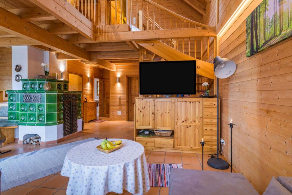 sala de estar con mesa y TV de pantalla plana en Holzhaus Oberbrändi, 