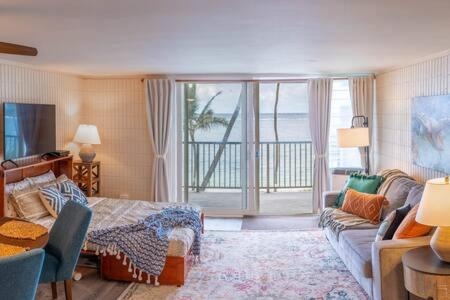 a living room with a couch and a bed and a living room with at Condo on Beach with AC in Laie