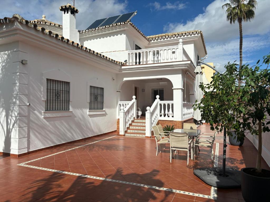 Casa blanca con patio con sillas en Gran villa en Torremolinos, en Torremolinos