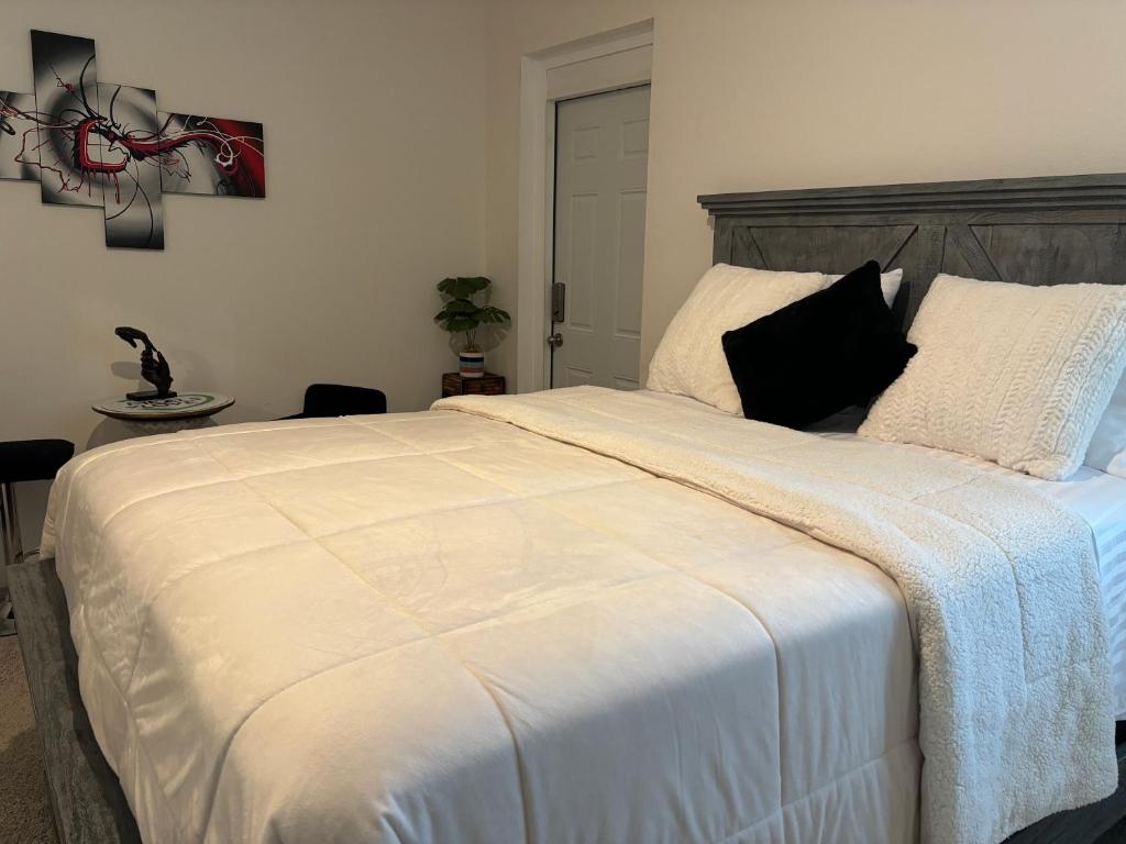 a bedroom with a large white bed with black pillows at Luxe Escape in De Leon Springs