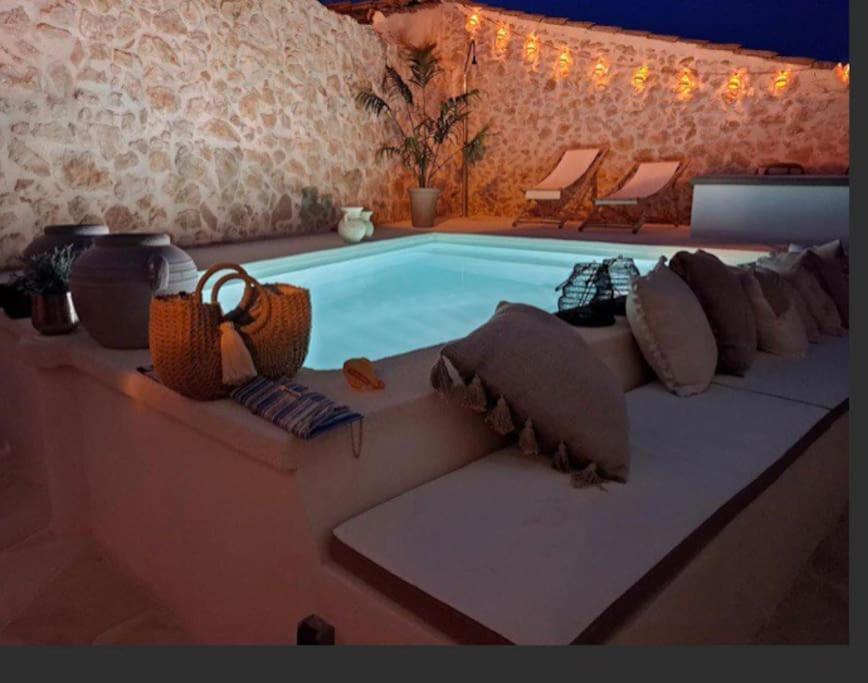 una piscina con cojines y sillas junto a ella en Casa de las Flores, en Cañada del Trigo