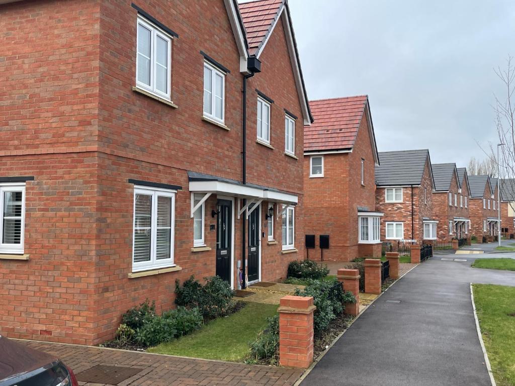 a row of brick houses on a street at The willows in Hardingstone