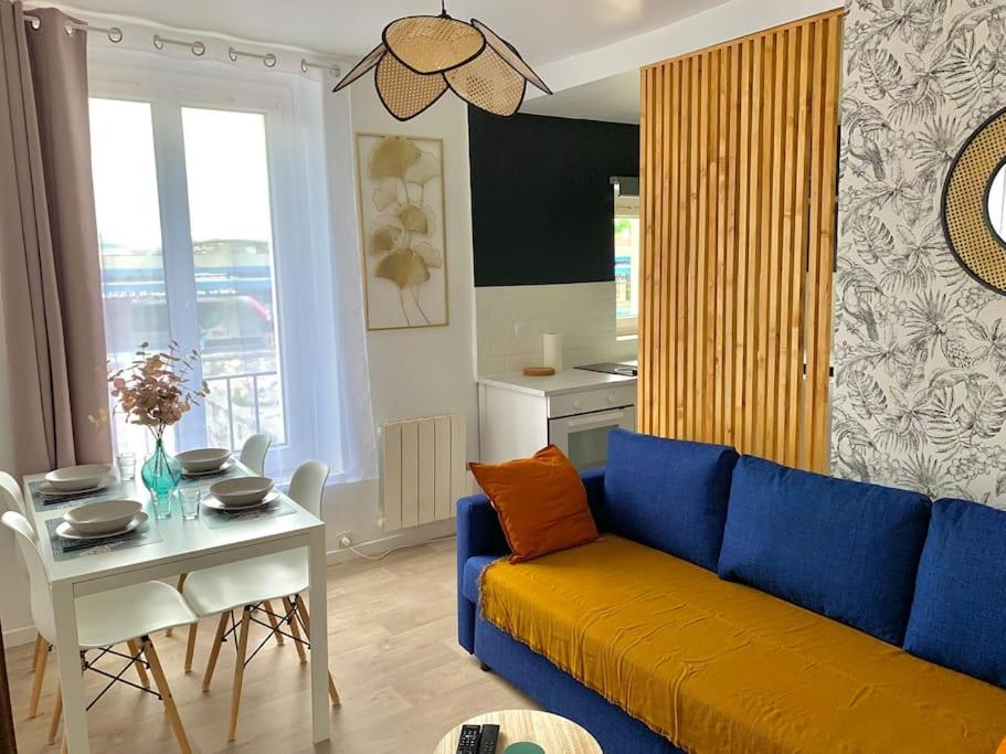 ein Wohnzimmer mit einem blauen Sofa und einem Tisch in der Unterkunft T2 Cosy near to Disney - Paris - Airport in Meaux