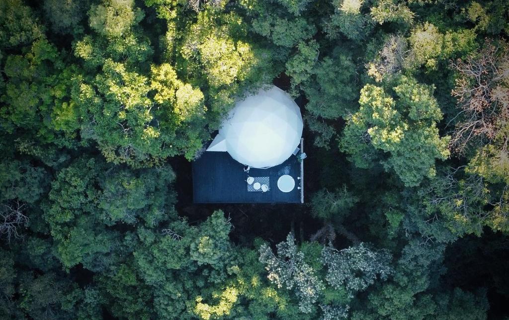 an aerial view of a silo in the middle of a forest at Domo Supernova by @highlowstays in Gramado