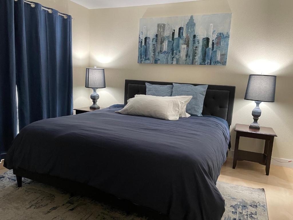 a bedroom with a large bed with blue curtains at Newly Remodeled Family Friendly 3B/2B House in Henderson