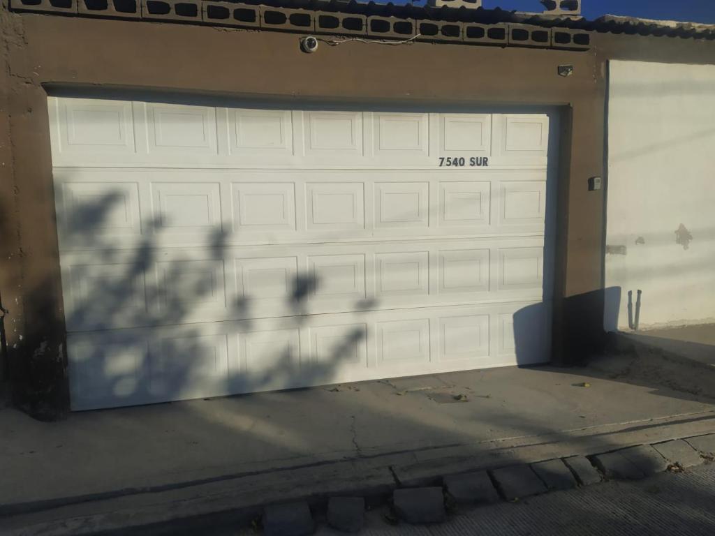 Una puerta de garaje blanca con el número. en Departamento familiar accesible , cerca del consulado y centros comerciales en Ciudad Juárez