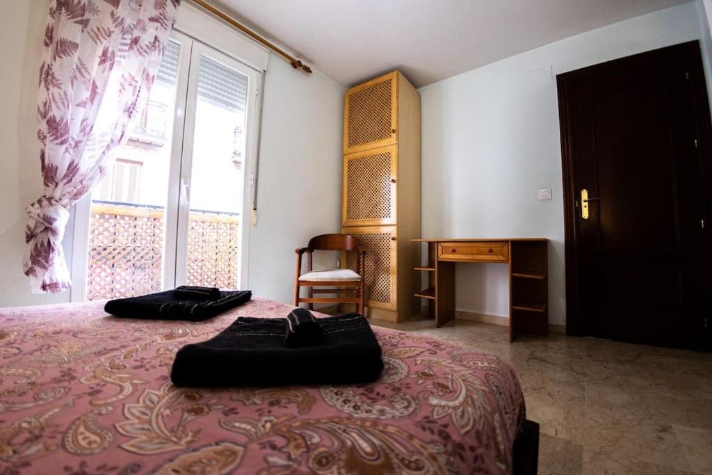 um quarto com uma cama grande com dois objectos pretos em Elvira 81 em Granada