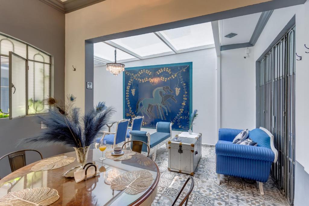 a dining room with blue chairs and a glass table at Casa Amatlán Ciento Dos in Mexico City