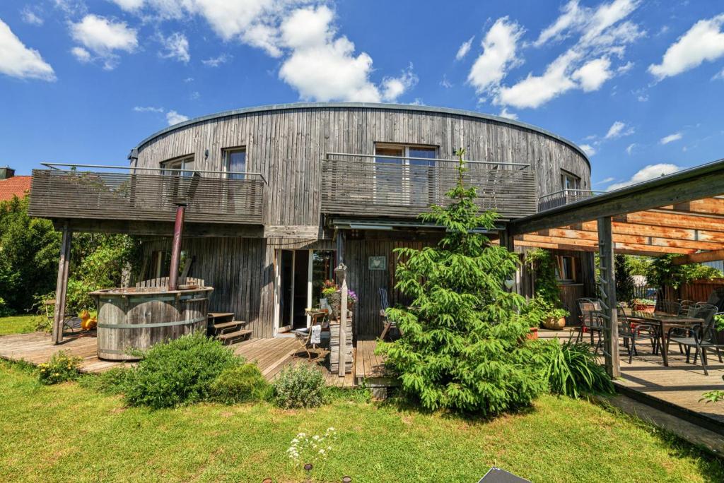 una casa rotonda in legno con terrazza e patio. di Ferienhaus Dornstetten a Dornstetten