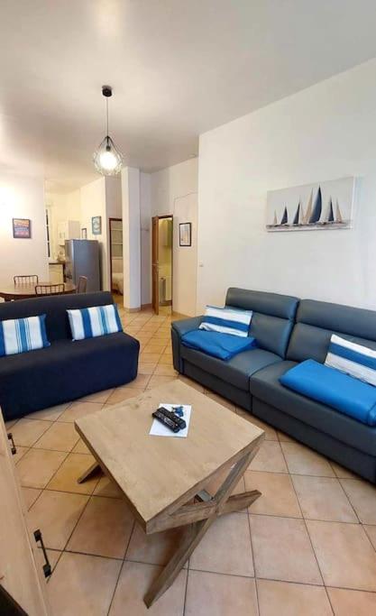 un salon avec un canapé bleu et une table dans l'établissement Le calme au centre-ville dans une cour intérieure, avec place de parking privée, à Dieppe