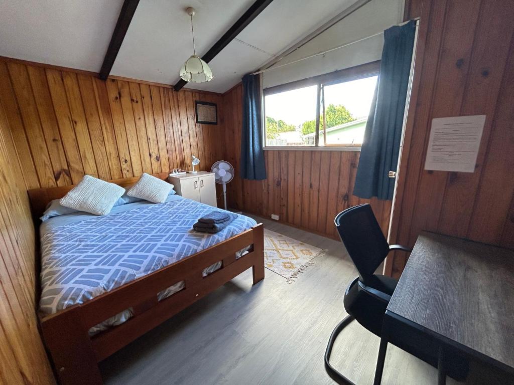 - une chambre avec un lit, une table et une chaise dans l'établissement Sister’s place, à Auckland