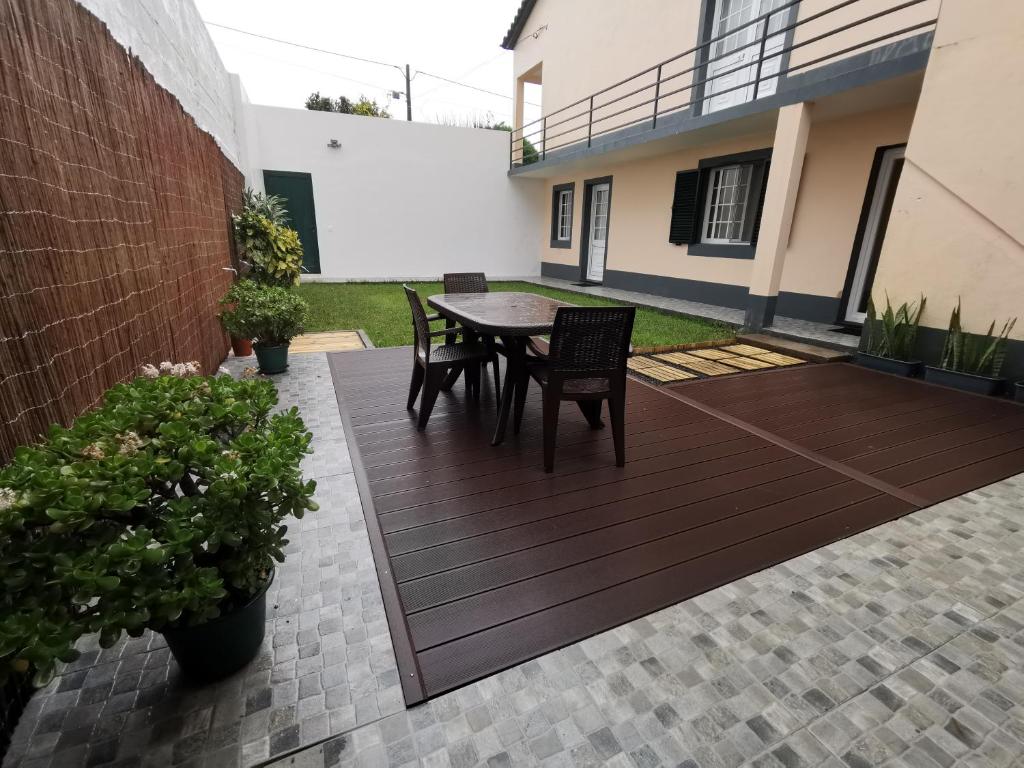 patio ze stołem i krzesłami oraz budynek w obiekcie Vila Viegas w mieście São Vicente Ferreira