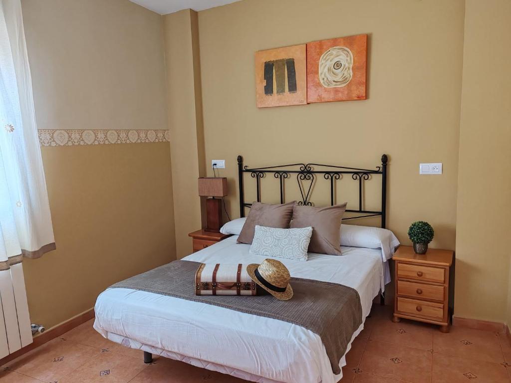 a bedroom with a bed with a hat on it at Ruralguejar in Güéjar-Sierra