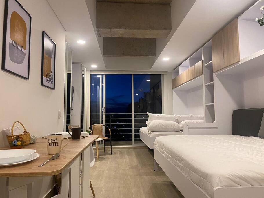 um quarto com uma cama, uma mesa e um sofá em Maravilloso loft con vista al atardecer - 707 em Bogotá